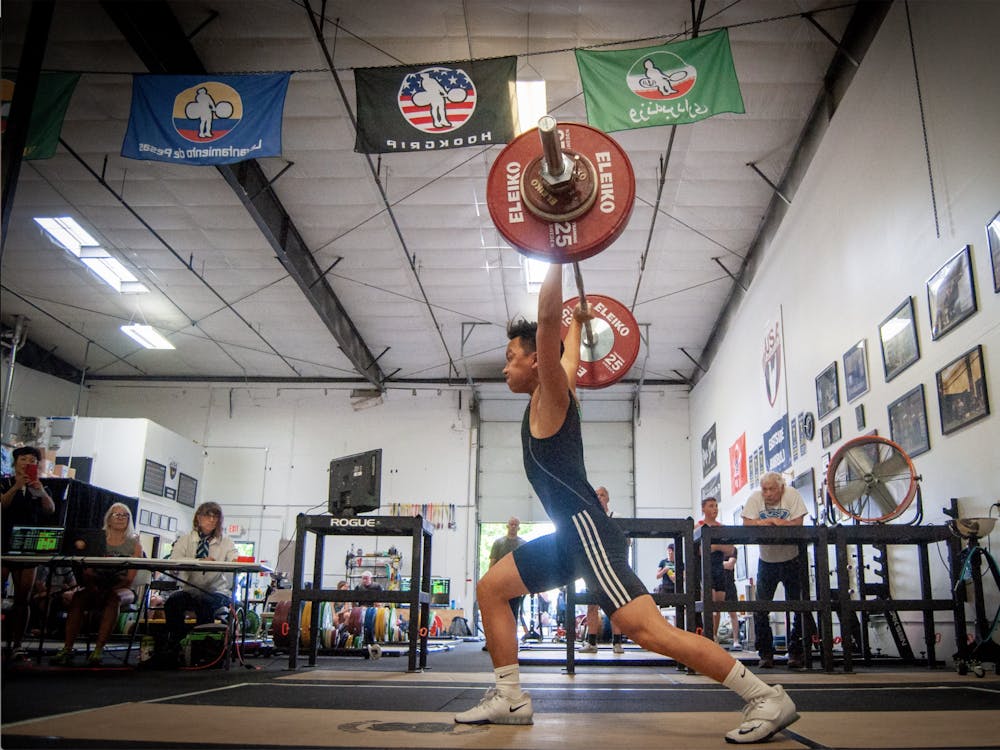 Tu doing a clean overhead at the Eastside Barbell Meet. Tu holds the record for snatch and clean and jerk in the 61kg weight class. Photo courtesy of Victor Tu