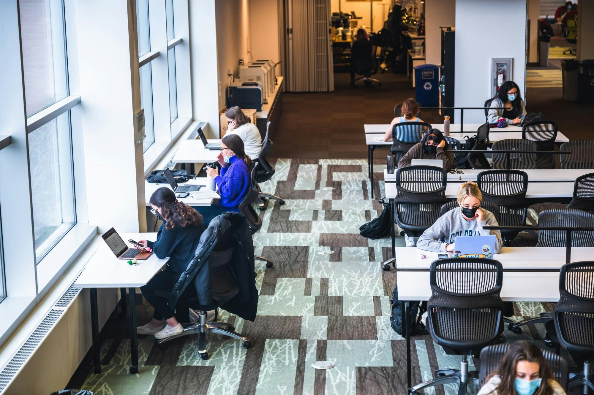 Masked students study in the Clark Library. 