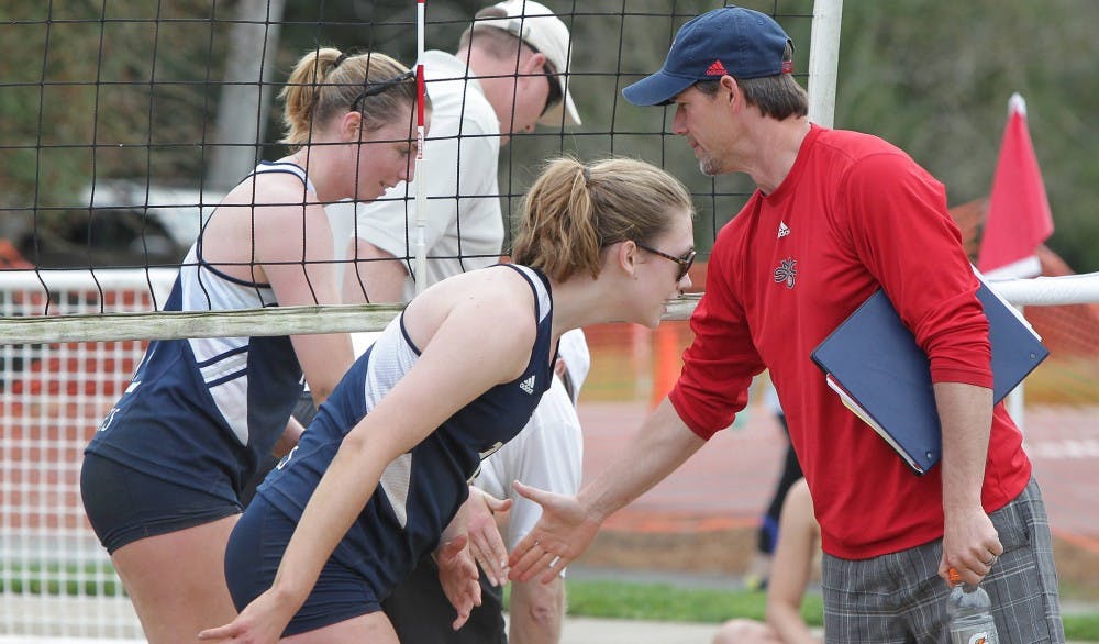  Photo courtesy of Tod Fierner/SMC Athletics | Volleyball head coach Brent Crouch congratulates Kristina Graven and Rachel Gillcrist during a March 14, 2013 sand volleyball match versus Pacific at Moraga Commons in Moraga, Calif.