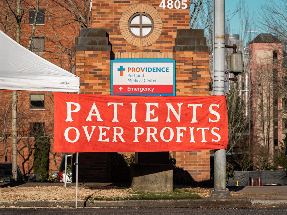 A banner stating "Patients over profits" hangs in front of the Providence Portland Medical Center sign on NE Glisan St.