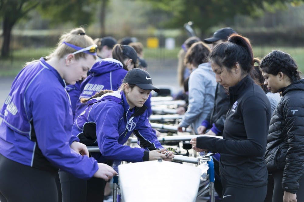 Senior captain Jacquelyn Bass helps prepare a boat before rowing practice.