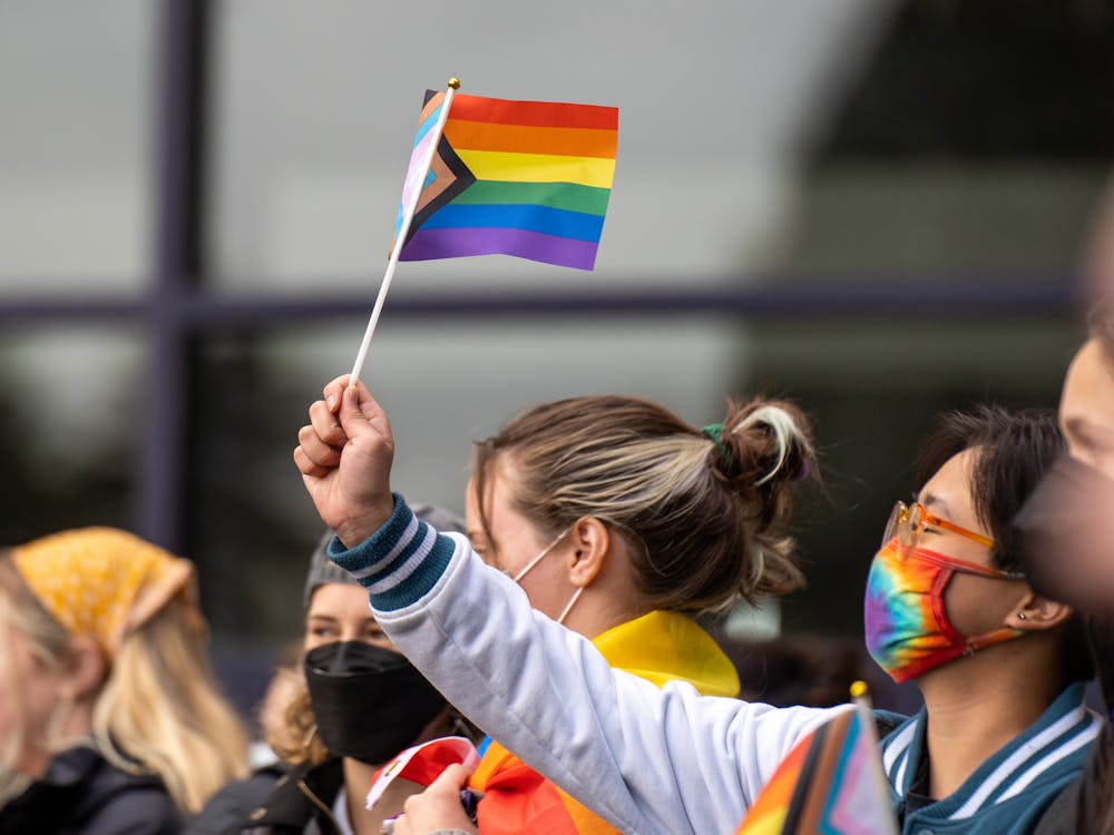 A student waves a pride flag at the Fr. Dan Parrish protest in 2022. 
