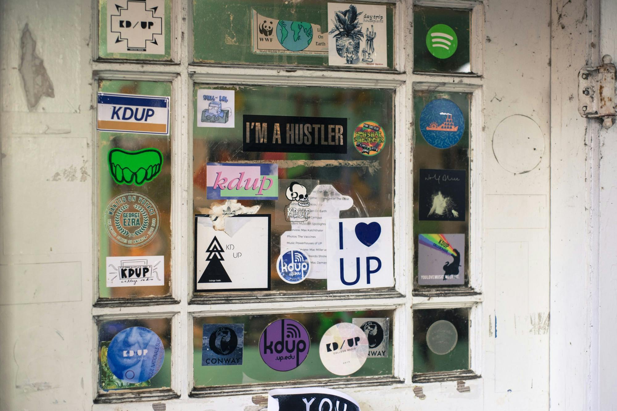The front door of The Shack, KDUP's recording and broadcasting studio, is littered with stickers from throughout the years.