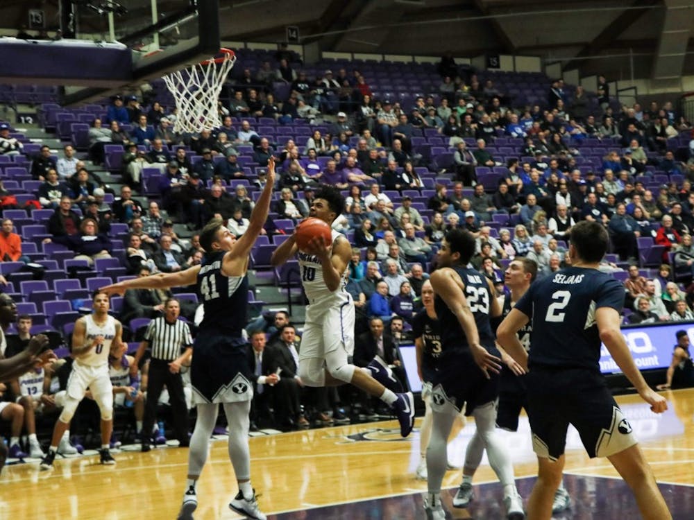 Marcus Shaver Jr. explodes off the ground trying to score with a defender in his face.