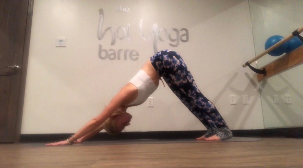 <p>Senior Meg Scharnagl perfecting her downward-facing dog at The Hot Yoga Barre. <em>Photo courtesy of Scharnagl.&nbsp;</em></p>