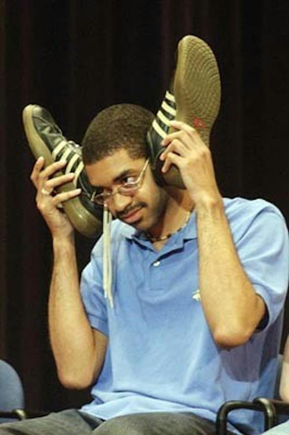 Student (name unknown) is told by hypnotist Tom Deluca that music is coming out of his shoes. The hypnotist's show was part of the No Place Like Penn weekend.