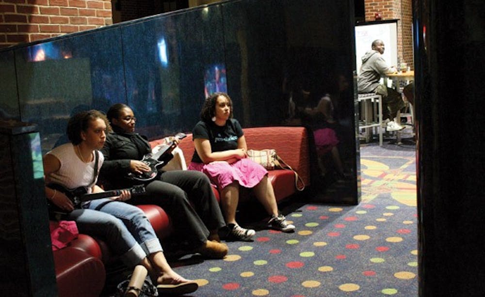 Christie Barrows, '11, Emilie Joseph, '09, and Kelly Barrows, '09, play guitar hero Monday night at the preview of the new game room in the Commons.