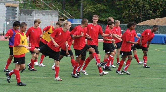 The Men's Soccer team stretching together.