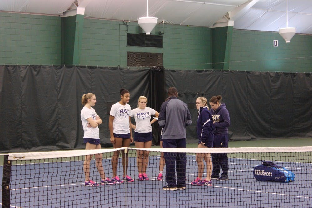 Navy coach gathers with the team to reflect on the doubles matches and talk strategy before the singles matches begin.