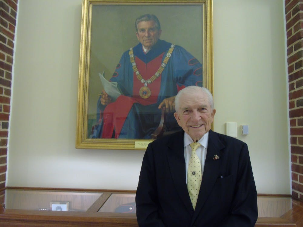 E. Bruce Heilman stands in front of his portrait hanging in the Heilman Dining Center.