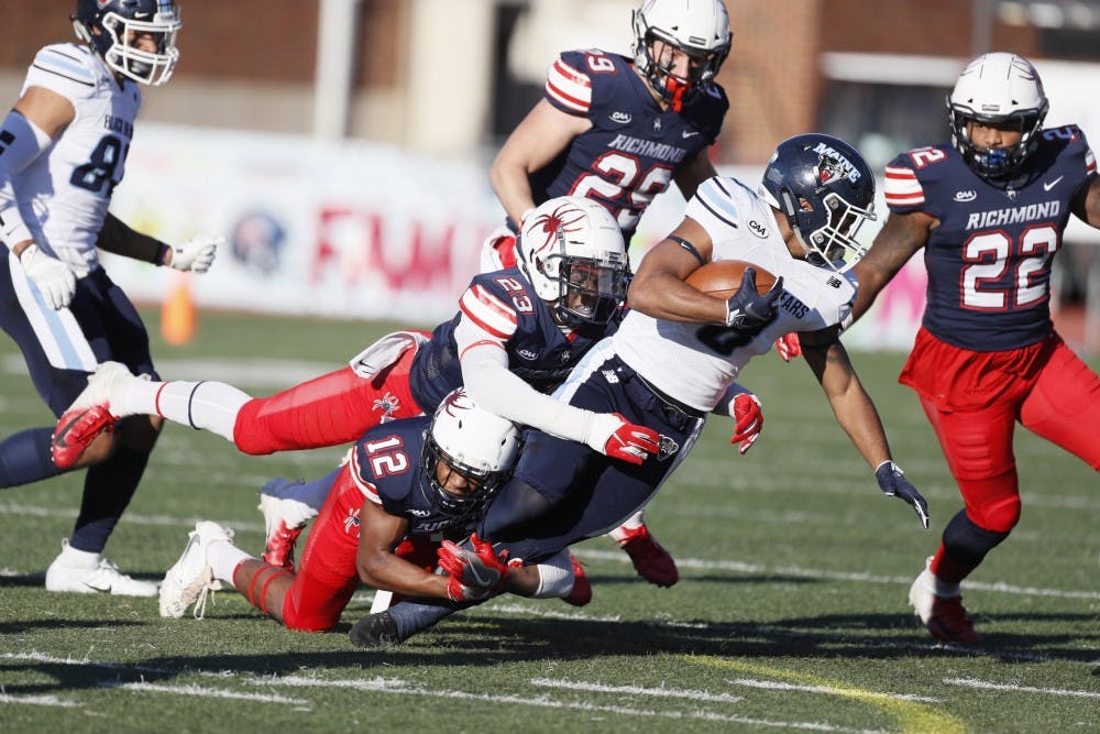 Sophomore Markus Vinson (12) and junior Daniel Jones (23) make a tackle during the Spiders' last home game of the season on Nov. 10. 