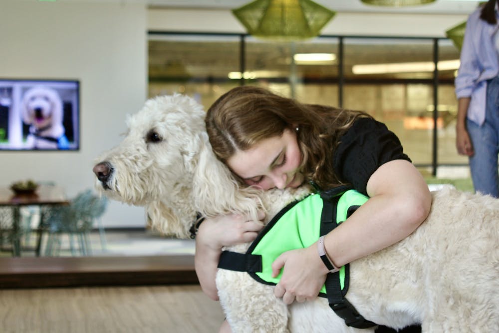 <p>Student embraces Emmett at his farewell party on Sept. 6 in the Well-Being Center.</p>