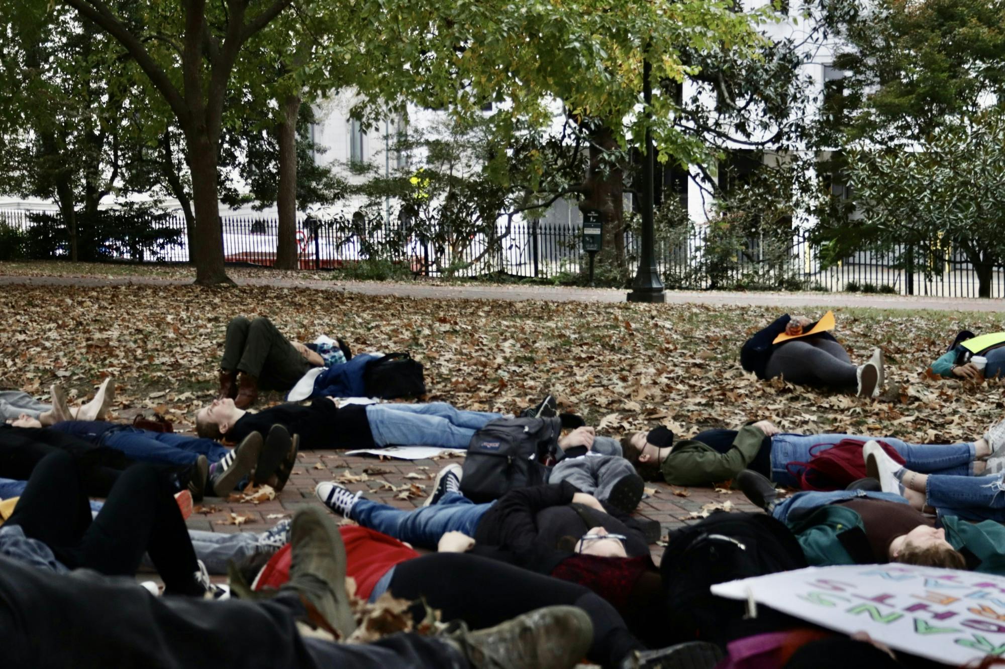 Protestors lay down in a moment of silence to honor the trans people who have died due to the effects of transphobia Sunday, Oct. 23, 2022