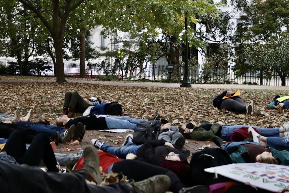 <p>Protestors lay down in a moment of silence to honor the trans people who have died due to the effects of transphobia Sunday, Oct. 23, 2022</p>