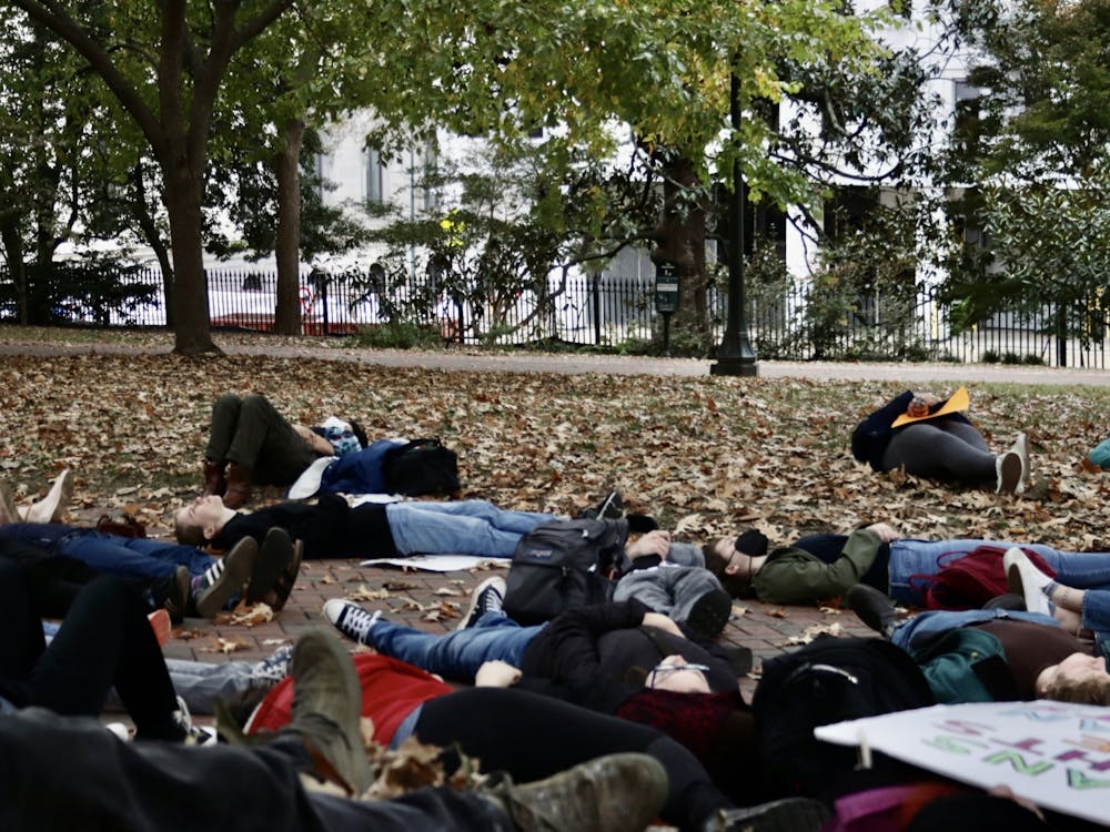 Protestors lay down in a moment of silence to honor the trans people who have died due to the effects of transphobia Sunday, Oct. 23, 2022