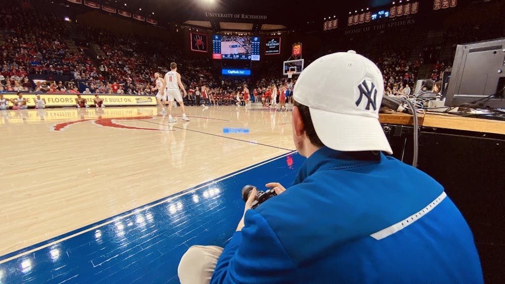 <p>Kyle Gardner sitting courtside in the University of Richmond Robins Center during the Feb. 29 game against University of Massachusetts Amherst.</p>