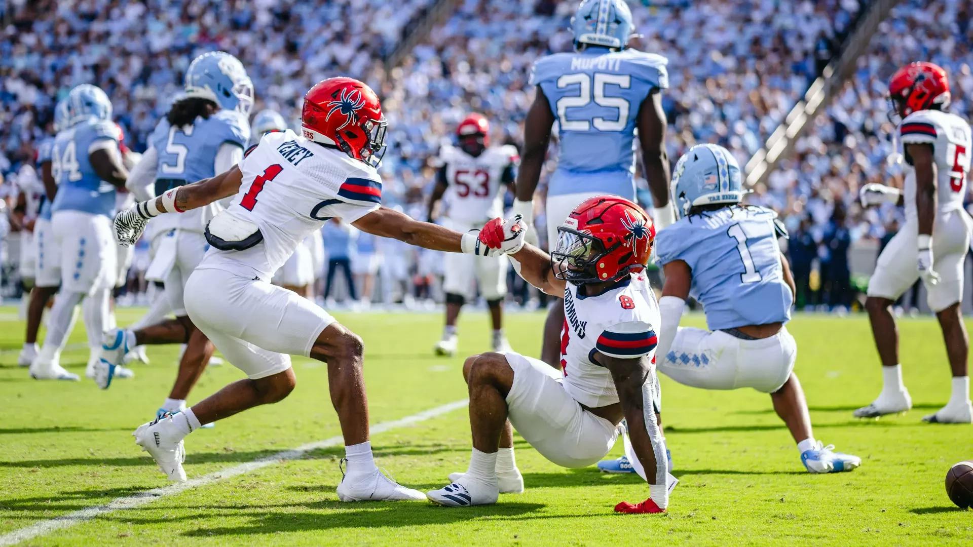 Senior wide receiver Quanye Veney helps up another player at Richmond's game against the University of North Carolina at Chapel Hill. Courtesy of Richmond Athletics