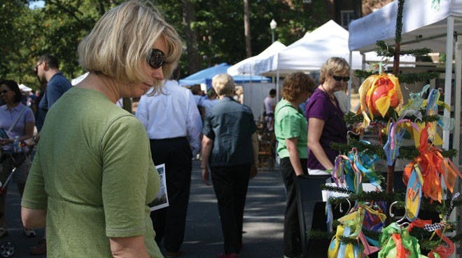 Local residence is looking at hand made ornamante at Art around Lake. 