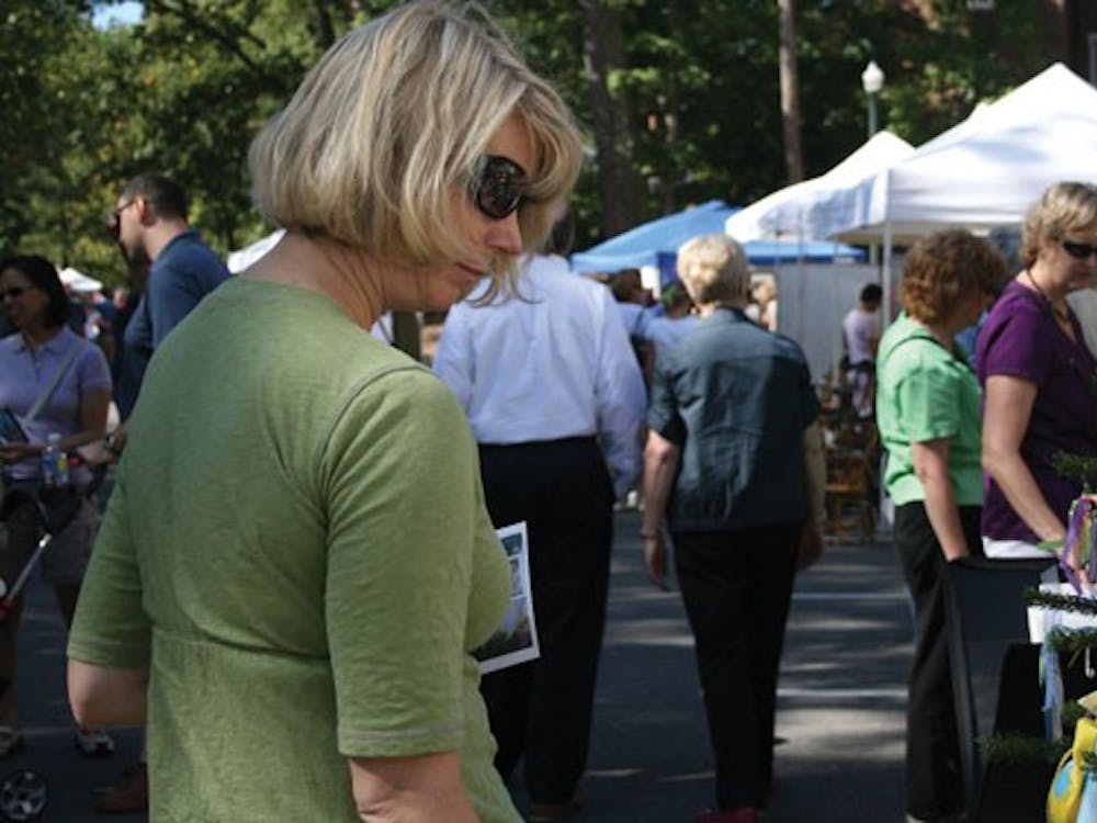 Local residence is looking at hand made ornamante at Art around Lake.