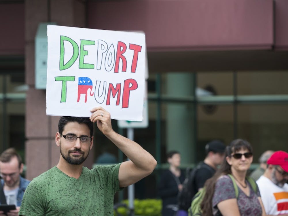 Protesters gather outside the Minneapolis Convention Center. This particular protester seems to have a problem with Trump's immigration policies.&nbsp;