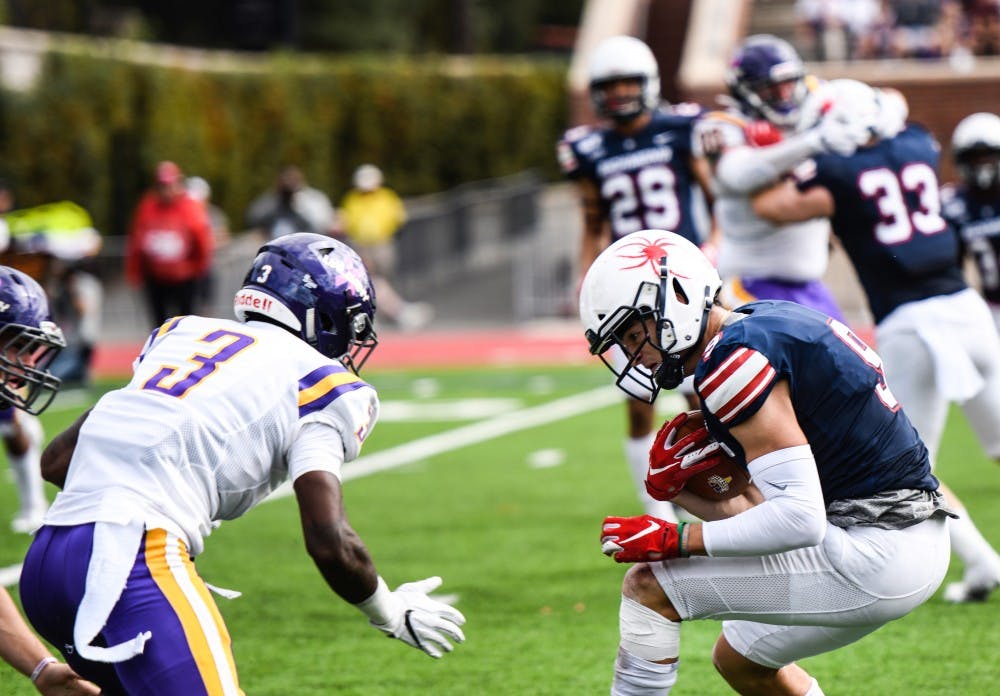 <p>Wide receiver graduate student Charlie Fessler avoids Albany's defense during the game on Saturday, Oct. 5, 2019.&nbsp;</p>