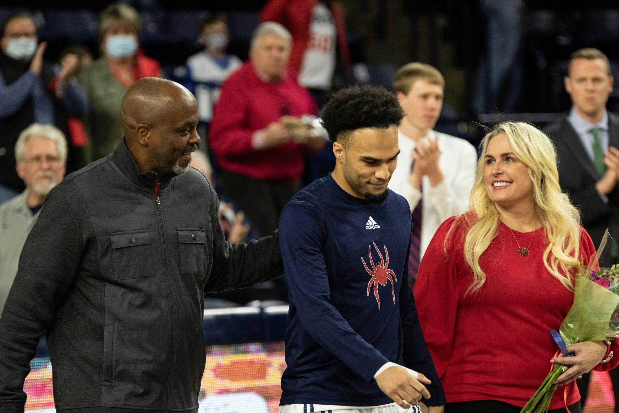 Graduate guard Jacob Gilyard walks with his family for the senior night celebration at the game against Saint Louis on Feb. 25