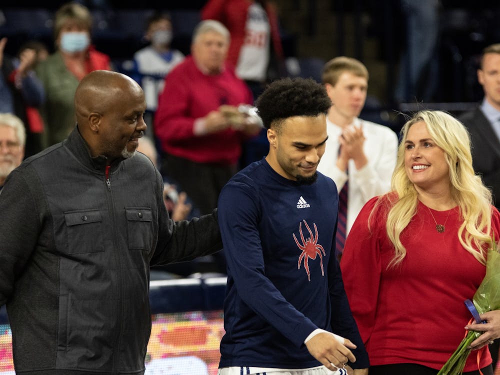 Graduate guard Jacob Gilyard walks with his family for the senior night celebration at the game against Saint Louis on Feb. 25