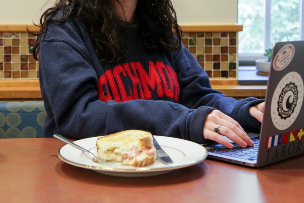 A patron at Passport Café enjoys their sandwich on a reusable ceramic plate. The use of glassware in the cafes is one of several new initiatives by University Dining Services in an effort to improve campus sustainability. &nbsp;