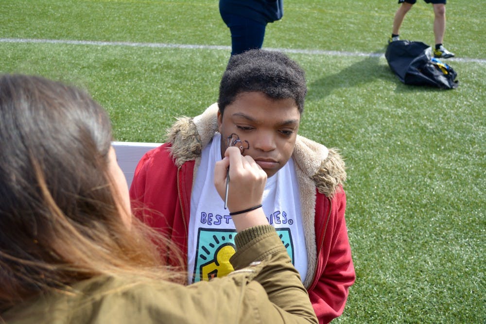 Sophomore Maria Vennikov paints Nemo on Janea Summers' face.