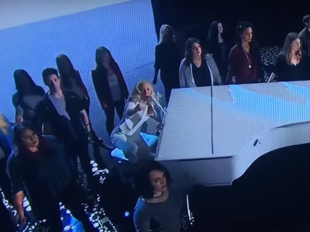 Lady Gaga, on the piano, is surrounded by sexual assault survivors&nbsp;as she performs Till it Happens to you at the 88th Academy Awards | Courtesy of YouTube