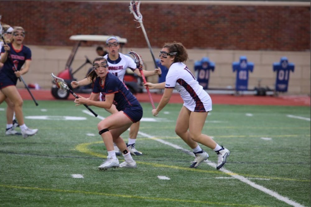 <p>Senior Kathleen Berkery, who decided to quite the lacrosse team, dodges a defender during an in-season game against Duquesne. <em>Photo courtesy of the A-10 network.&nbsp;</em></p>