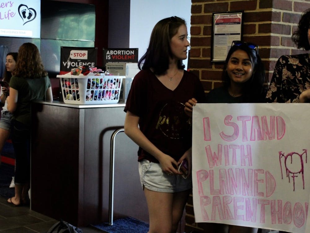 Lillian Sullivan, WC'20, and Nimisha Bangalore, WC'20, protest Spiders for Life, an anti-abortion group on campus. 