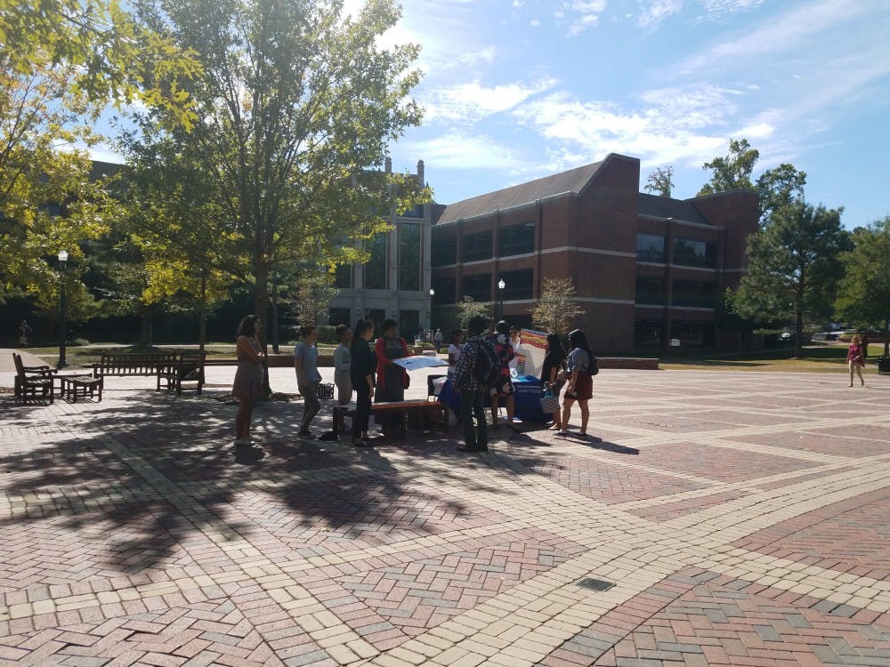 <p>Participants of the Give Five, Take Five event on Friday&nbsp;speak to students about suicide prevention and sell donuts for Richmond's Out of the Darkness Walk.</p>