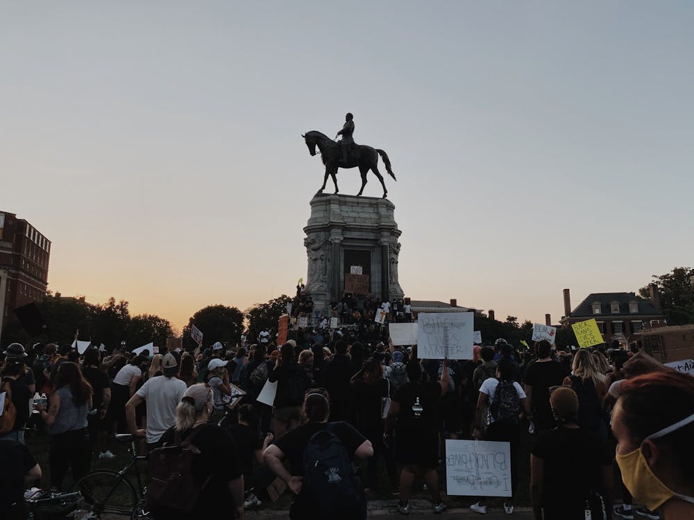 Protesters gather on June 2 around the Robert E. Lee statue on Monument Avenue, where demonstrators stand on the statue, which is covered with graffiti.&nbsp;