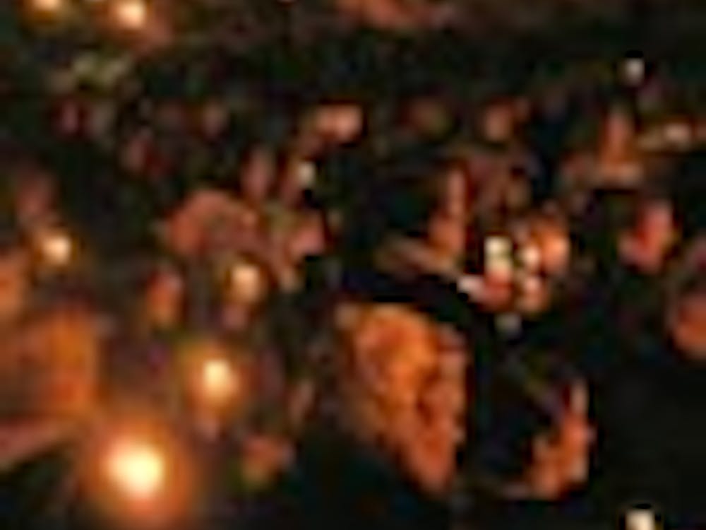 The many attendees of the Take Back the Night event Tuesday evening joined together at the end to light candles in the dark.