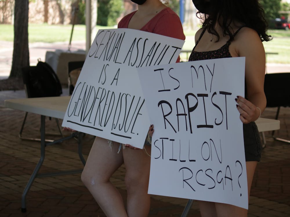 Students gathered on the Forum on April 22 to protest rape culture on campus. The silent protest was organized by junior Hoor Ain as a continuation of events regarding sexual assault in the past month. Students wore masks and held signs supporting free speech. In the silence, a prospective student on a tour passing by asked, "Oh, does rape happen a lot here?" Photos by Madyson Fitzgerald.