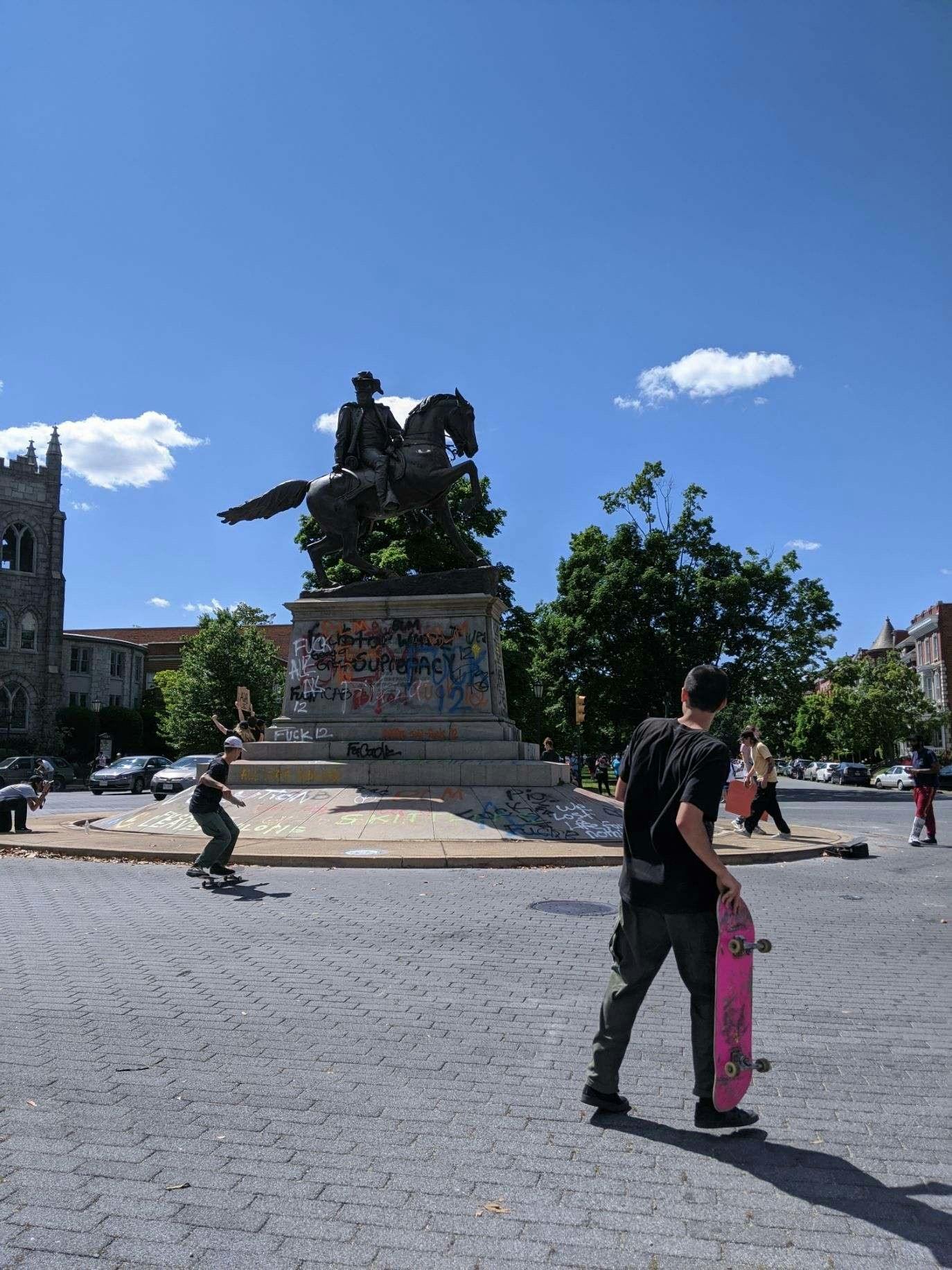 People skateboarding on and around the J.E.B. Stuart statue, now covered with graffiti, on Monument Avenue on May 31.