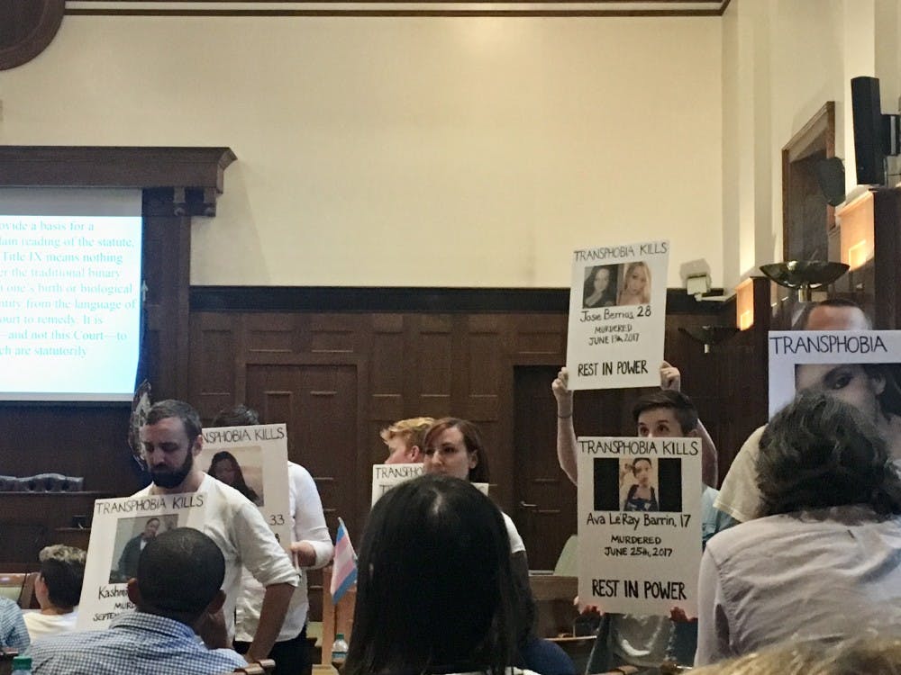 <p>Student protesters in all white holding posters of transgender people who were either murdered or committed suicide due to transphobia during Ryan T. Anderson's talk at the law school.</p>