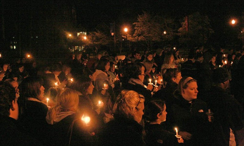 The many attendees of the Take Back the Night event Tuesday evening joined together at the end to light candles in the dark.