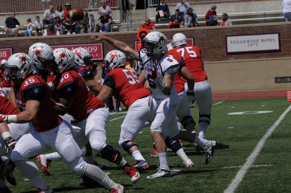 <p>Starting quarterback Kyle Lauletta launches a ball over the offensive line during the first half of the annual spring game that took place on Saturday in the Robins Center | Photo courtesy of Richmond Athletics</p>