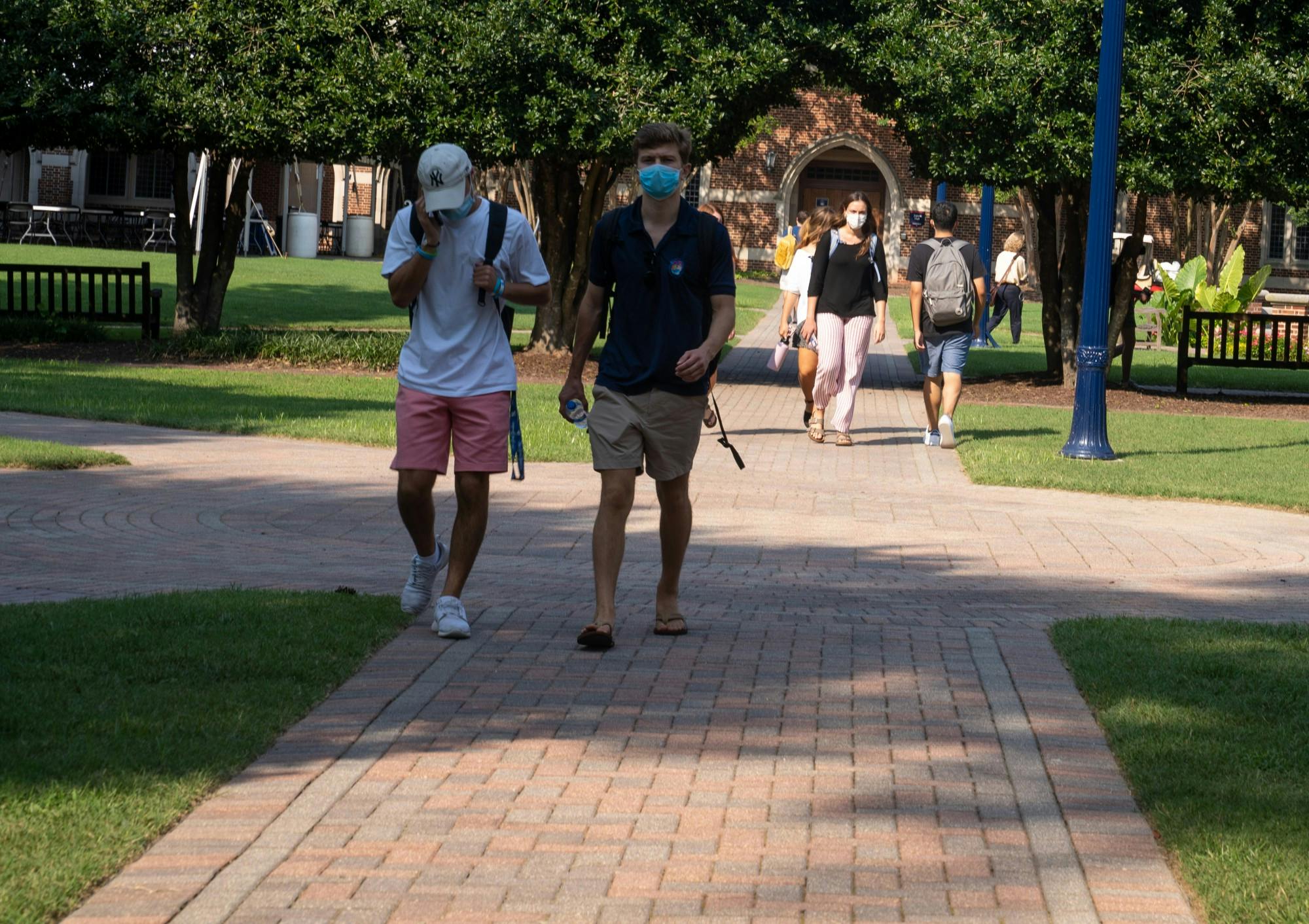 Students walk in the Stern Quadrangle in between classes with their masks on.&nbsp;
