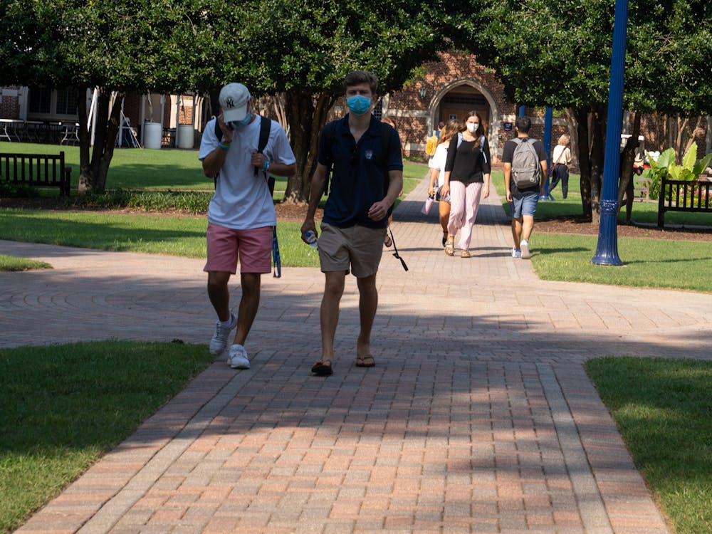 Students walk in the Stern Quadrangle in between classes with their masks on. 
