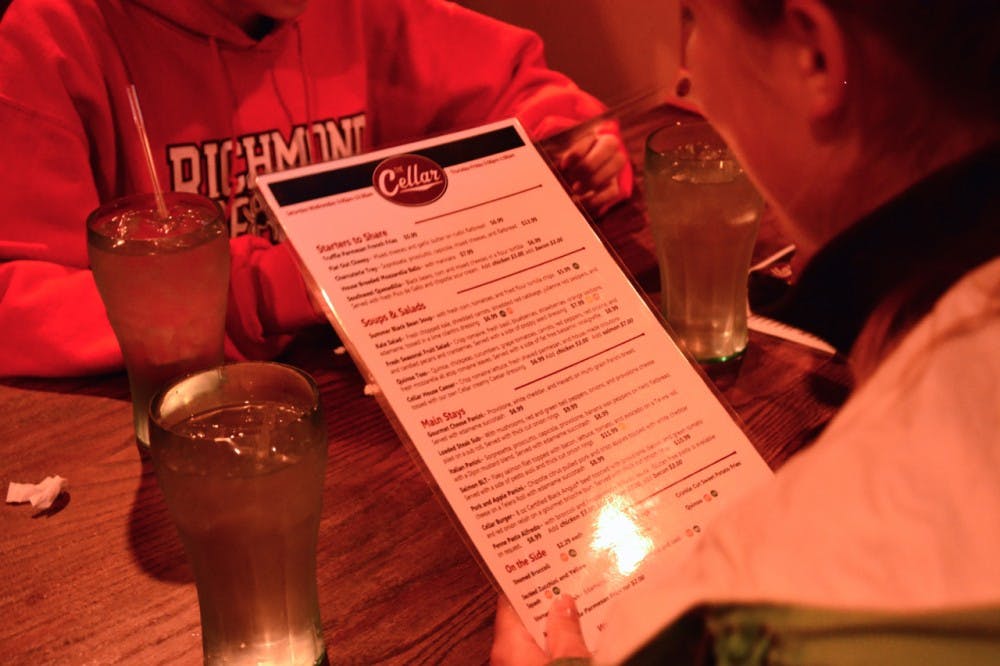 <p>Students take a look at the new menu offered at The Cellar.</p>