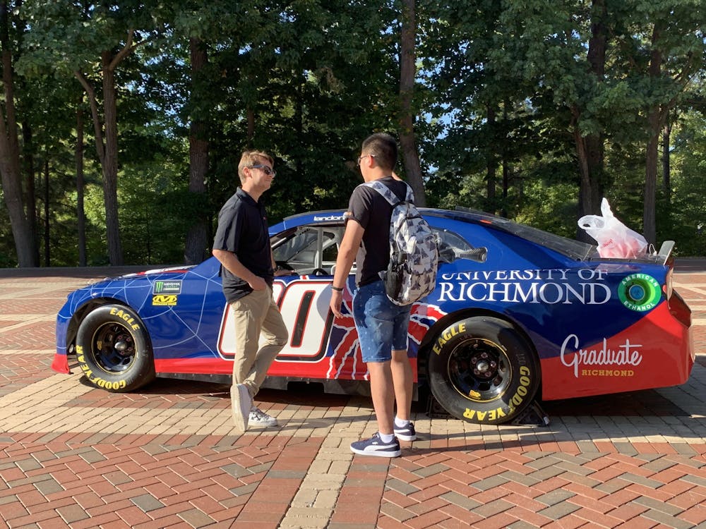 <p>Driver Landon Cassill, left, chats with a student in the Forum on Thursday, Sept. 19, 2019. The University of Richmond sponsored a car in the race at the Richmond Raceway on Sept. 21 and had a public showing of a replica model on campus.&nbsp;</p>