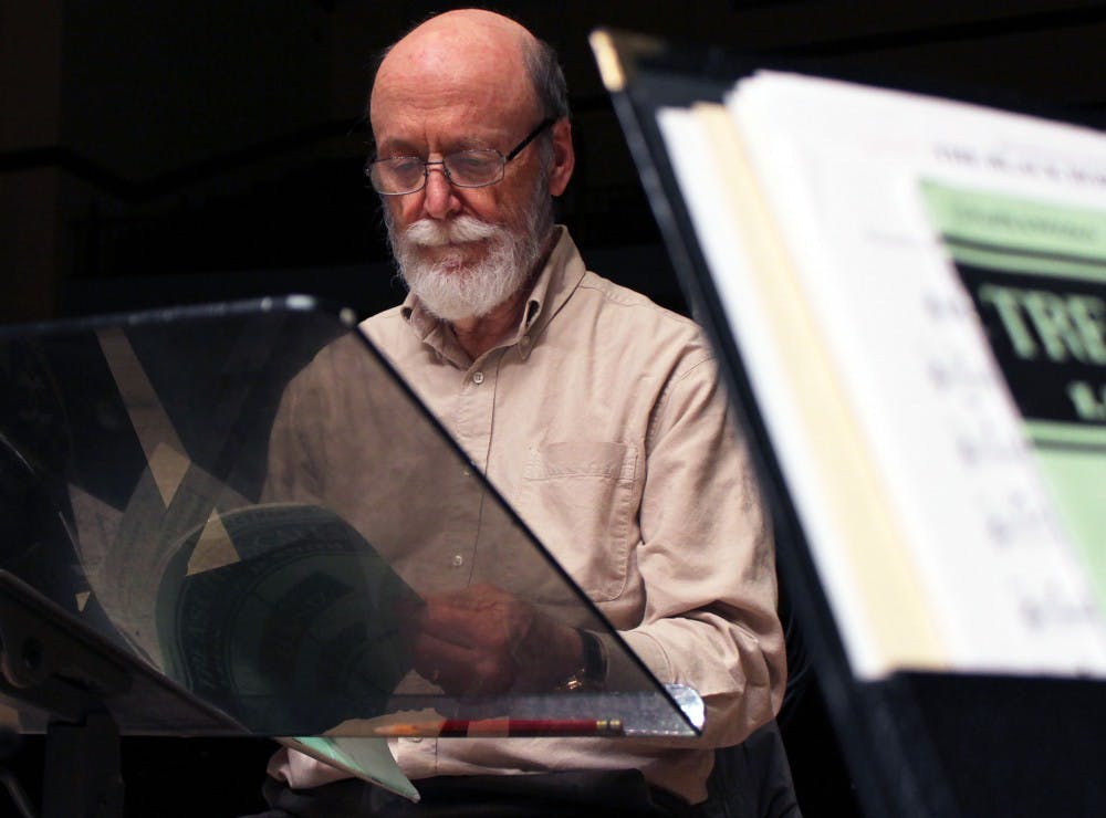 <p>David Niethamer flips through a book of music.&nbsp;</p>