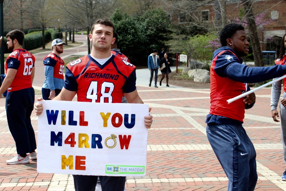 <p>Football players recruit students to join the bone marrow registry in the Forum on April 11, 2018.</p>