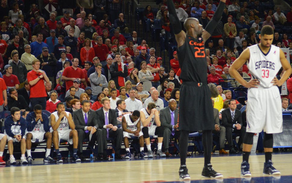 Miami's Tonye Jekiri (foreground) holds his hands up in celebration while Richmond's Kendall Anthony (background) swallows defeat in his last career game at Richmond. 