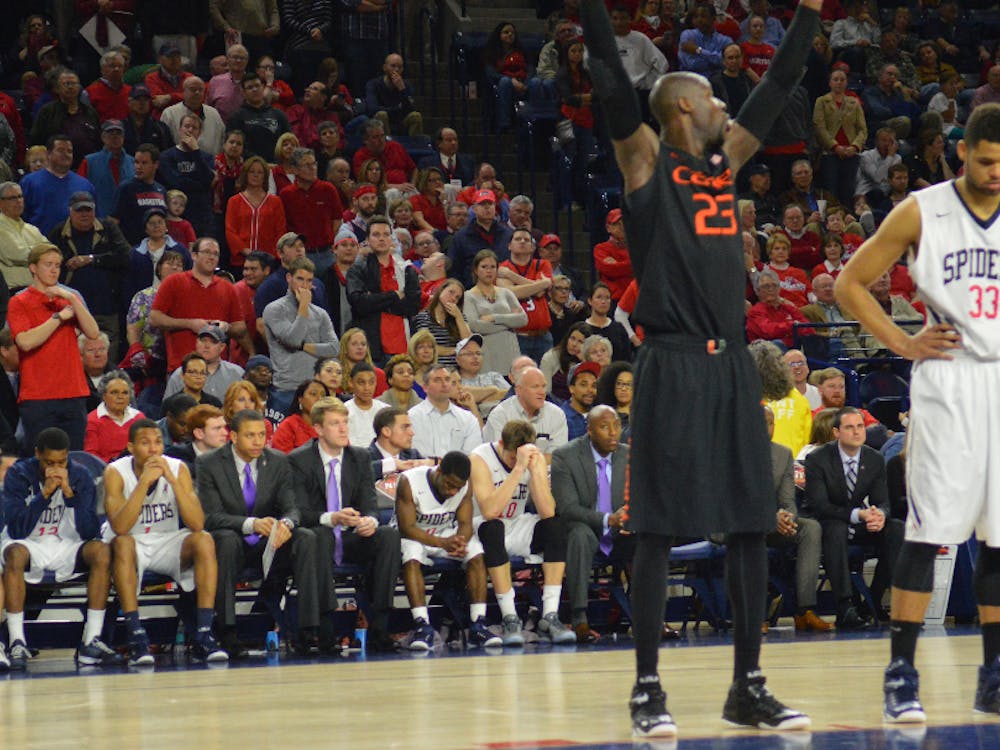 Miami's Tonye Jekiri (foreground) holds his hands up in celebration while Richmond's Kendall Anthony (background) swallows defeat in his last career game at Richmond. 