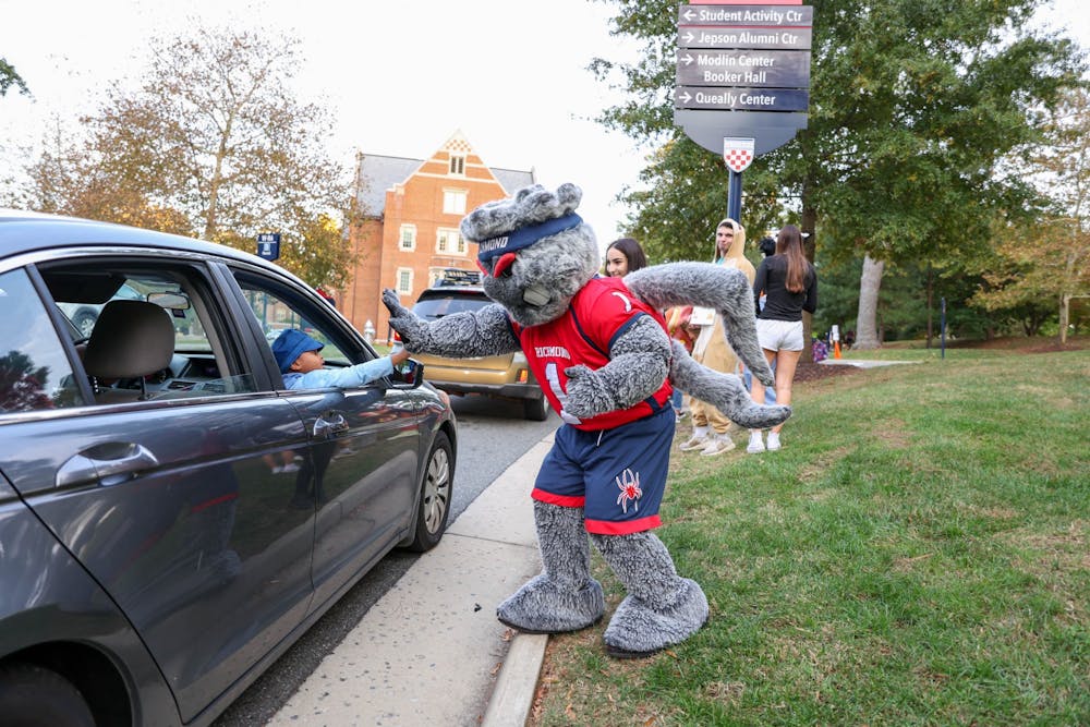 The University of Richmond mascot, "WebstUR," greets families with high-fives, dances, and waves as they enter the Trick or Treat Street event route.