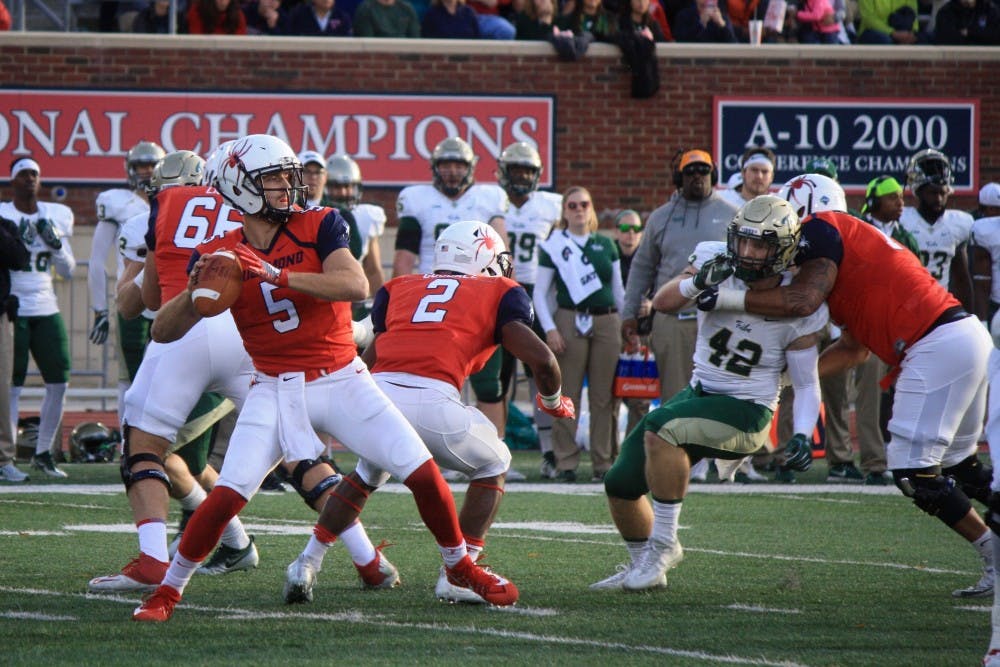 <p><em>Quarterback Kyle Lauletta&nbsp;looks to pass upfield under pressure.&nbsp;</em></p>